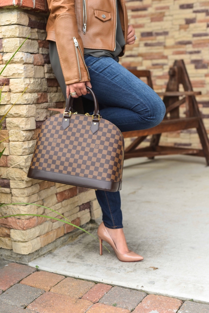 Luxury Handbag Collection and Review featured by top US fashion blog, LuxMommy: image of a woman wearing a Louis Vuitton Alma MM Ebene