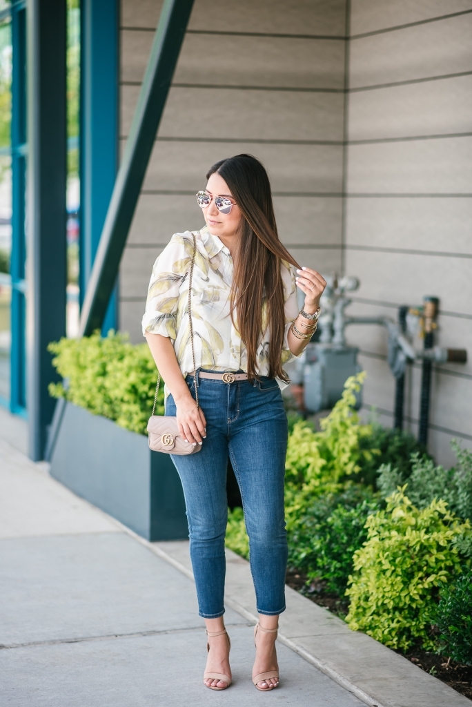 White House Black Market Summer Collection Favorites featured by top US fashion blog, LuxMommy: image of a woman wearing a White House Black Market leaf button down shirt, high rise skinny crop jeans, aviator sunglasses, hoop earrings, bangle bracelets, and cuff bracelet