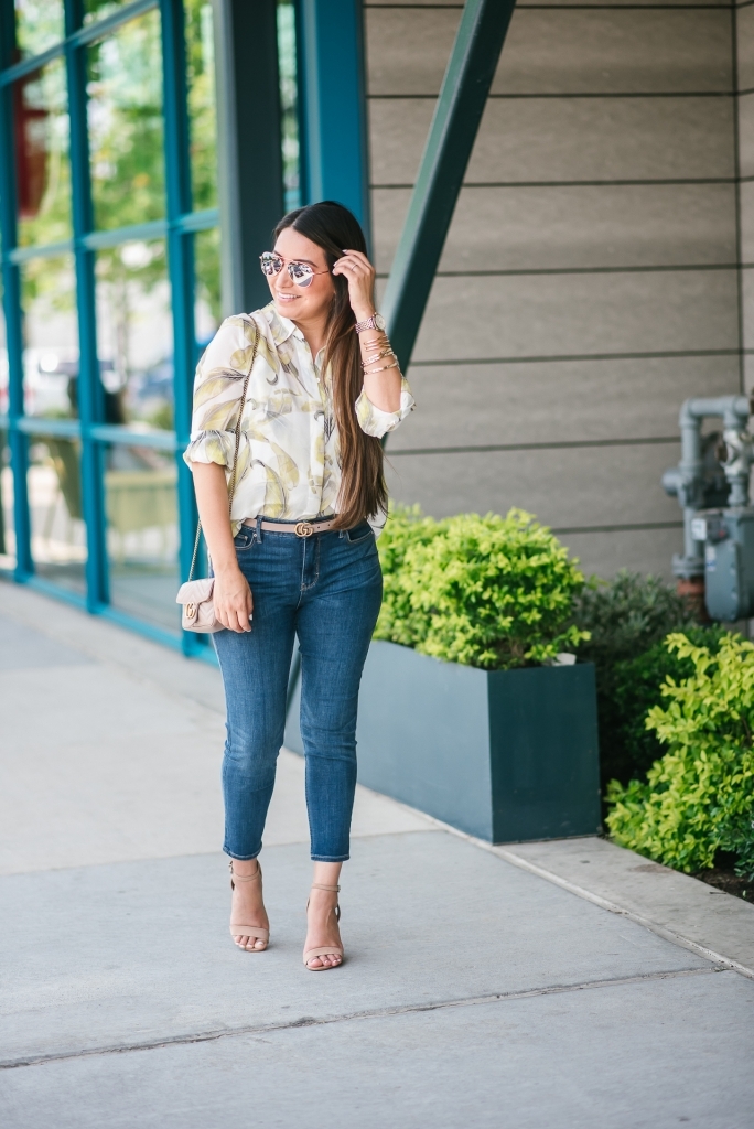 White House Black Market Summer Collection Favorites featured by top US fashion blog, LuxMommy: image of a woman wearing a White House Black Market leaf button down shirt, high rise skinny crop jeans, aviator sunglasses, hoop earrings, bangle bracelets, and cuff bracelet