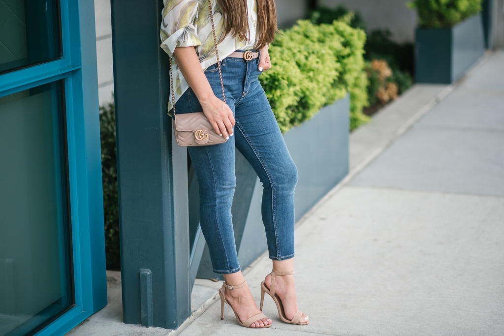 White House Black Market Summer Collection Favorites featured by top US fashion blog, LuxMommy: image of a woman wearing a White House Black Market leaf button down shirt, high rise skinny crop jeans, aviator sunglasses, hoop earrings, bangle bracelets, and cuff bracelet