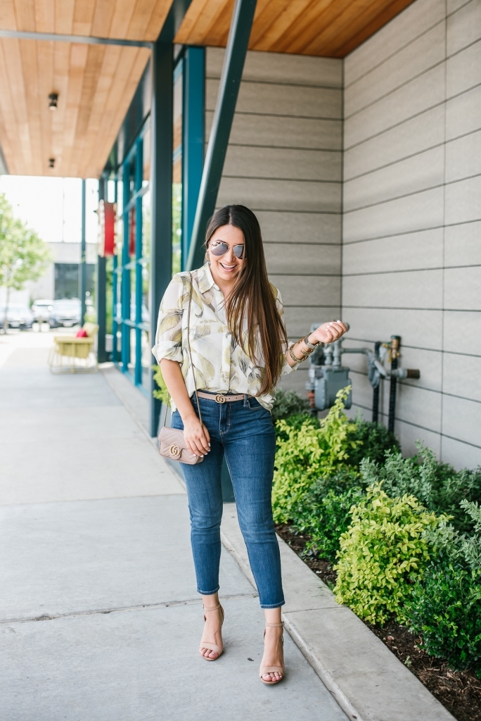 White House Black Market Summer Collection Favorites featured by top US fashion blog, LuxMommy: image of a woman wearing a White House Black Market leaf button down shirt, high rise skinny crop jeans, aviator sunglasses, hoop earrings, bangle bracelets, and cuff bracelet