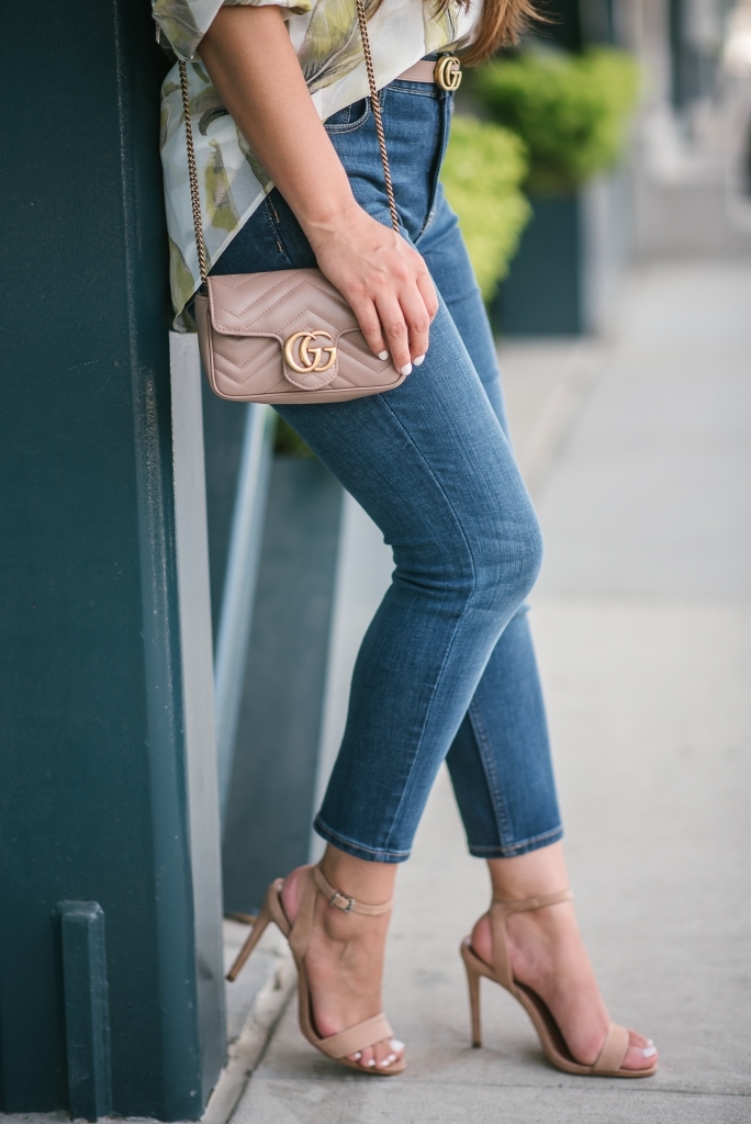 White House Black Market Summer Collection Favorites featured by top US fashion blog, LuxMommy: image of a woman wearing a White House Black Market leaf button down shirt, high rise skinny crop jeans, aviator sunglasses, hoop earrings, bangle bracelets, and cuff bracelet