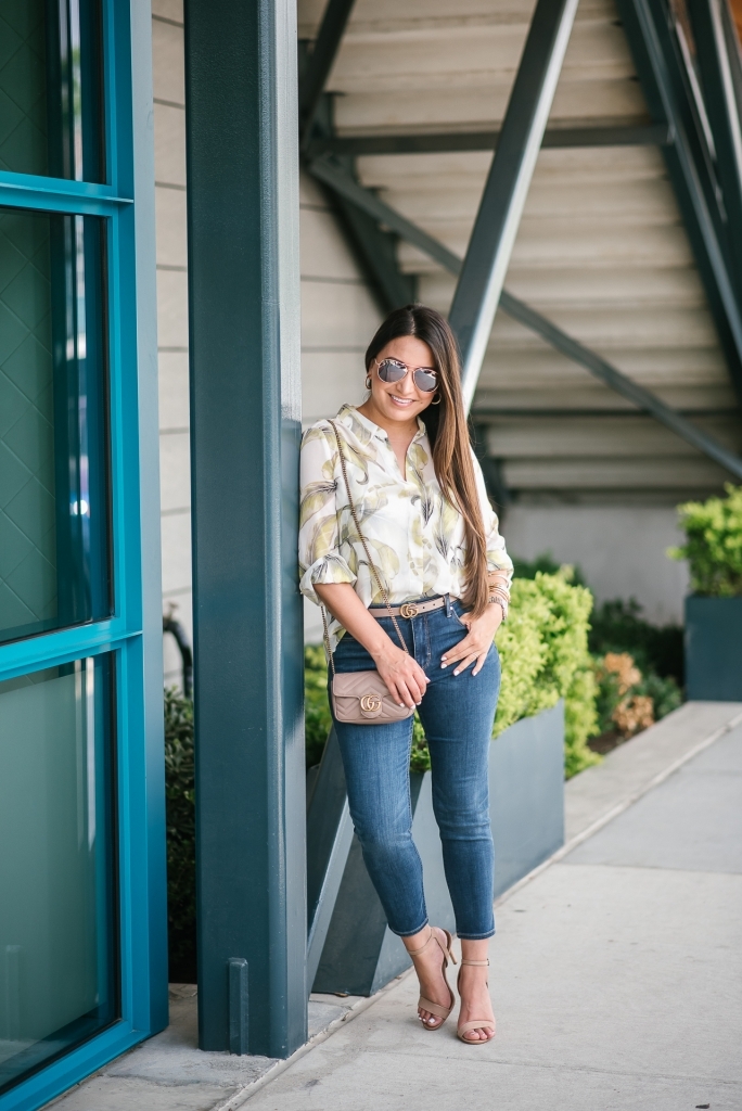 White House Black Market Summer Collection Favorites featured by top US fashion blog, LuxMommy: image of a woman wearing a White House Black Market leaf button down shirt, high rise skinny crop jeans, aviator sunglasses, hoop earrings, bangle bracelets, and cuff bracelet