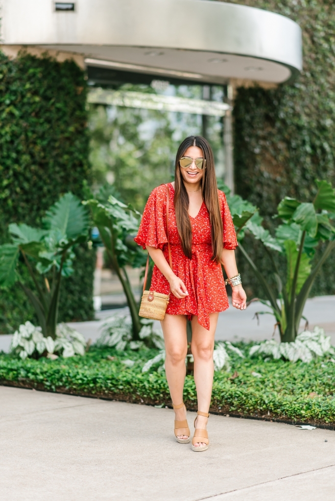 Summer essentials featured by top US fashion blog, LuxMommy: image of a woman wearing a Jack floral romper, Treasure & Bond wedge sandals, Antik Kraft straw bag, Quay Australia aviator sunglasses, Michele diamond watch, David Yurman bracelet, Argento Vivo necklace and Gorjana hoop earrings.