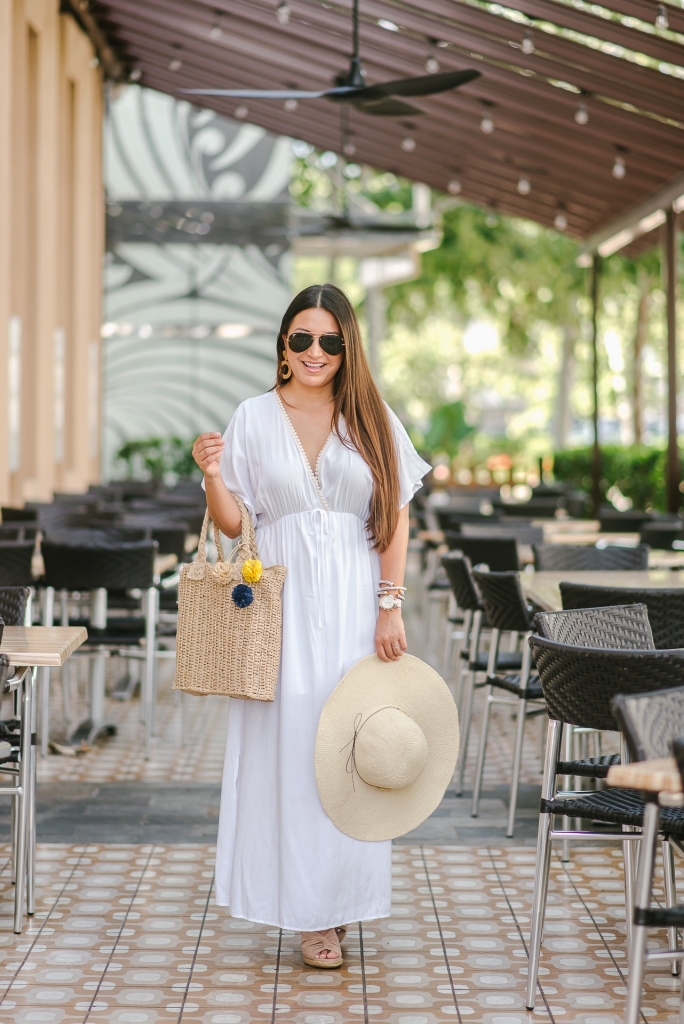 Cute Walmart summer dresses featured by top US fashion blog, LuxMommy: image of a woman wearing an LA Gypsy white maxi dress, Eliza May Rose straw hat, Eliza May Rose pom bag, Michele gold watch, POP fashioner aviator sunglasses and Sam Edelman wedge espadrilles