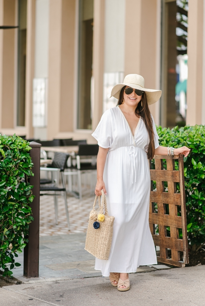 Cute Walmart summer dresses featured by top US fashion blog, LuxMommy: image of a woman wearing an LA Gypsy white maxi dress, Eliza May Rose straw hat, Eliza May Rose pom bag, Michele gold watch, POP fashioner aviator sunglasses and Sam Edelman wedge espadrilles
