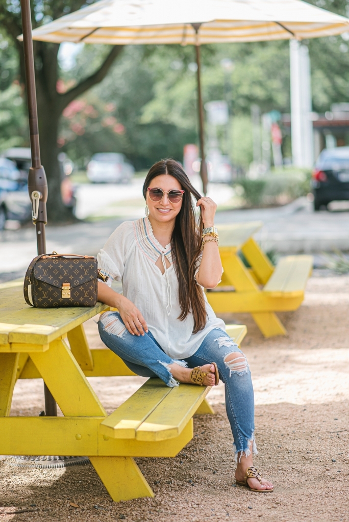 Rainbow smocked top styled for summer by top US fashion blog, LuxMommy: image of a woman wearing a Madewell rainbow smocked top, Express mid rise jeans, Tory Burch flip flops, Kendra Scott drop earrings, Michele diamond watch, Stella & Dot spike bracelet and Louis Vuitton crossbody bag.