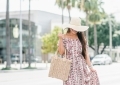 Affordable Summer Dresses featured by top US fashion blog, LuxMommy: image of a woman wearing a Cherokee floral hi low dress, Eliza May Rose straw sunhat, Eliza May Rose pom bag, Sam Edelman wedge espadrilles, Quay Australia studded aviator sunglasses, Michele diamond watch, and a David Yurman bracelet.