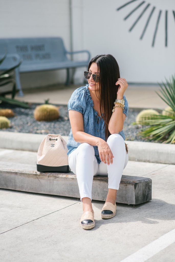 Chanel Gabrielle Backpack review featured by top US fashion blog, LuxMommy: image of a woman wearing a Chanel Gabrielle Backpack, Tory Burch cap toe flat, NYDJ chambray top, Quay Australia studded sunglasses, Michele diamond two tone watch, Stella & Dot bracelet, and a Kendra Scott charm bracelet.