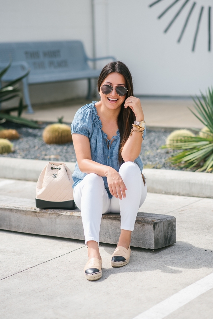 Chanel Gabrielle Backpack review featured by top US fashion blog, LuxMommy: image of a woman wearing a Chanel Gabrielle Backpack, Tory Burch cap toe flat, NYDJ chambray top, Quay Australia studded sunglasses, Michele diamond two tone watch, Stella & Dot bracelet, and a Kendra Scott charm bracelet.