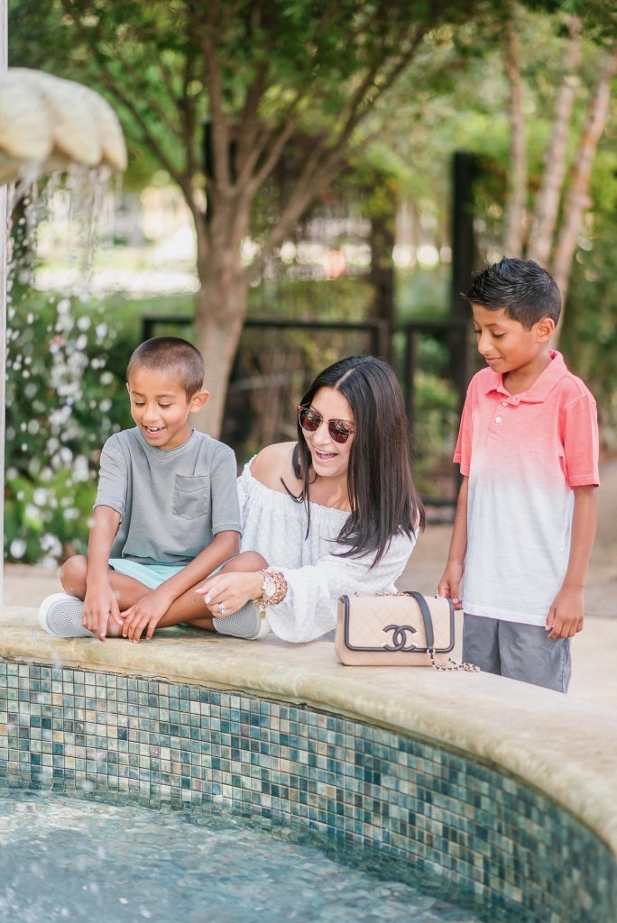 Back to School Style with Walmart by popular Texas fashion blog, Lux Mommy: image of a mom and her two boys looking in to a courtyard fountain. 