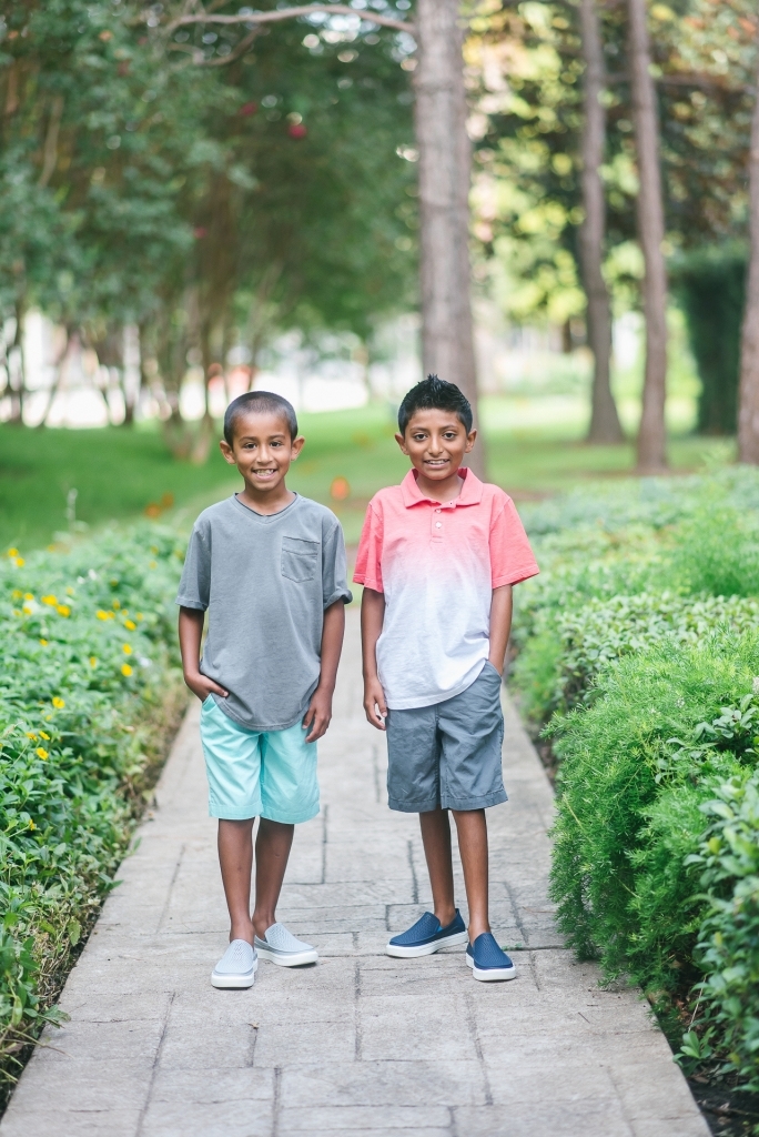 Back to School Style with Walmart by popular Texas fashion blog, Lux Mommy: image of two boys standing next to each other on a brick pathway outside and wearing a Walmart Wonder Nation Short Sleeve Ombre Jersey Polo, The Children's Place Pull On Woven Jogger Short, and Crocs Unisex Junior CitiLane Roka Shoes.