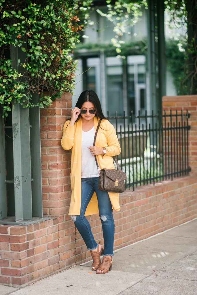 Affordable Fall Transitional Outfit by popular Texas fashion blog, Lux Mommy: image of a woman leaning up against a brick building and wearing a Walmart Heart N Crush Women's Long Striped Cardigan, Clementine Apparel Women's Deep V-Neck Short Sleeve T-Shirt, Sofia Jeans by Sofia Vergara Sofía Skinny Destructed Mid Rise Ankle Jean Women's (Medium Wash), and Women Big Buddha Woven Peep Toe shoe.