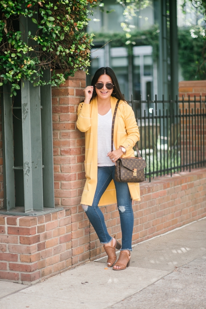 Affordable Fall Transitional Outfit by popular Texas fashion blog, Lux Mommy: image of a woman leaning up against a brick building and wearing a Walmart Heart N Crush Women's Long Striped Cardigan, Clementine Apparel Women's Deep V-Neck Short Sleeve T-Shirt, Sofia Jeans by Sofia Vergara Sofía Skinny Destructed Mid Rise Ankle Jean Women's (Medium Wash), and Women Big Buddha Woven Peep Toe shoe.