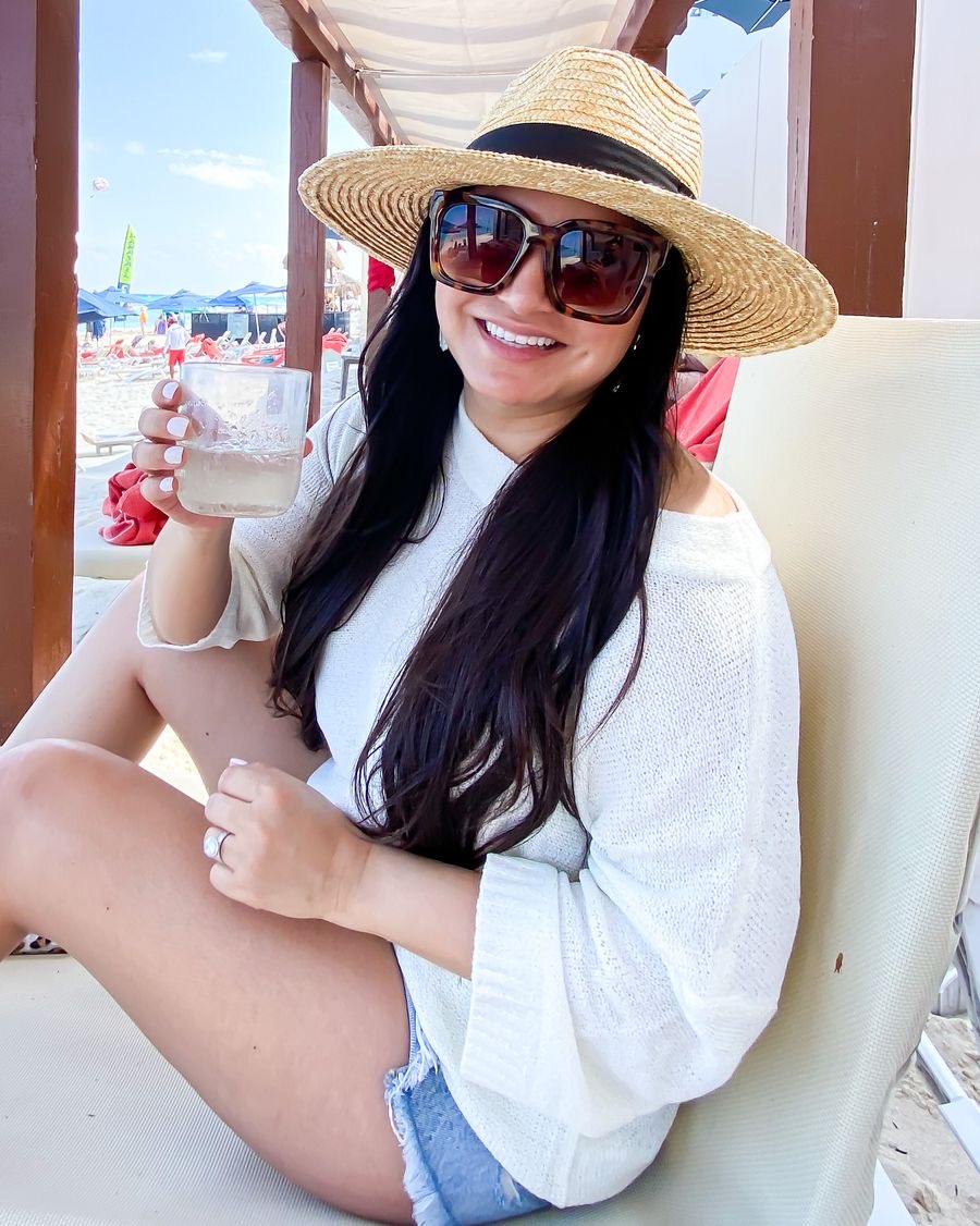 Houston top fashion and lifestyle blogger LuxMommy styles sweater set, denim cutoff shorts, and straw hat.